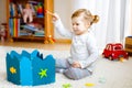 Adorable cute toddler girl playing with wooden fishing game at home or nursery. Happy healthy child training memory Royalty Free Stock Photo