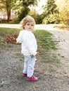 Adorable cute toddler girl walking in a park on autumn day. Happy child having fun outdoors. Autumnal activities with Royalty Free Stock Photo