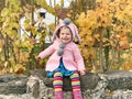 Adorable cute toddler girl walking in a park on autumn day. Happy child having fun outdoors. Autumnal activities with Royalty Free Stock Photo