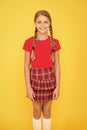 Adorable cutie. Cute little girl charming smile on yellow background. Happy small girl wearing red clothes. Girl with