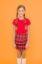 Adorable cutie. Cute little girl charming smile on yellow background. Happy small girl wearing red clothes. Girl with