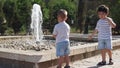 Adorable excited siblings waching the fater stream of the fountain