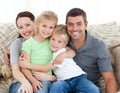 Adorable family sitting on the sofa and smiling