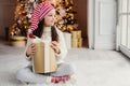 Adorable female child wears santa claus hat, warm clothes, hold Royalty Free Stock Photo