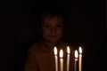 Adorable five year old kid celebrating his birthday and blowing candles on homemade baked cake, indoor. Birthday party for