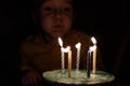 Adorable five year old kid celebrating his birthday and blowing candles on homemade baked cake, indoor. Birthday party