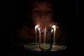 Adorable five year old kid celebrating his birthday and blowing candles on homemade baked cake, indoor. Birthday party