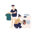 Adorable funny couple sorting clothes and putting it in washing machine. Cute smiling young man and woman doing laundry