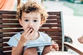 An adorable and funny little girl eats a cake in the yard Royalty Free Stock Photo