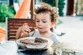 An adorable and funny little girl eats a cake in the yard Royalty Free Stock Photo