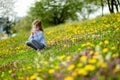 Adorable girl in blooming dandelion flowers