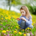 Adorable girl in blooming dandelion flowers