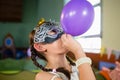 Adorable girl blowing balloon during birthday party Royalty Free Stock Photo