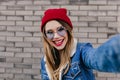 Adorable girl in blue glasses making selfie with inspired face expression. Photo of beautiful young Royalty Free Stock Photo