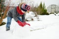 Adorable girl building a snowman in the backyard. Cute child playing in a snow. Winter activities for family with kids Royalty Free Stock Photo