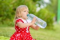 Adorable girl in dress drink water from bottle