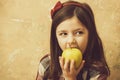 Adorable girl eating vitamin yellow apple