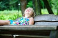 Adorable girl having fun on a wooden swing on summer day Royalty Free Stock Photo