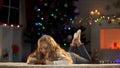 Adorable girl holding envelope with letter for Santa, belief in X-mas magic