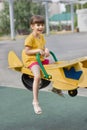 Little girl laughs and rolls on a seesaw on a playground