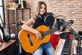 Adorable girl musician singing song playing classical guitar at music studio Royalty Free Stock Photo