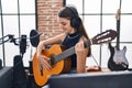 Adorable girl musician singing song playing classical guitar at music studio Royalty Free Stock Photo