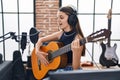 Adorable girl musician singing song playing classical guitar at music studio Royalty Free Stock Photo