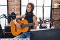 Adorable girl musician singing song playing classical guitar at music studio Royalty Free Stock Photo