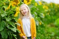 Adorable girl playing in blooming sunflower field on beautiful summer day. Royalty Free Stock Photo