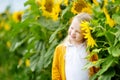 Adorable girl playing in blooming sunflower field on beautiful summer day. Royalty Free Stock Photo