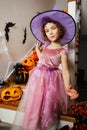 Adorable girl posing in pink dress and witch hat Royalty Free Stock Photo