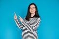 Adorable Girl in Striped Pullover Pointing and Gazing at Empty Space - Charming Young Female Model with Expressive