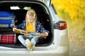 Adorable girl with a suitcase ready to go on vacations with her parents. Child looking forward for a road trip or travel. Autumn b Royalty Free Stock Photo