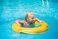 Adorable girl swim on yellow life ring in pool at protical beach