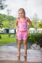 Adorable girl take shower under tree at tropical beach resort