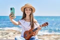 Adorable girl tourist make selfie by the smartphone playing ukulele at seaside Royalty Free Stock Photo