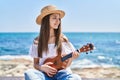 Adorable girl tourist smiling confident playing ukulele at seaside Royalty Free Stock Photo