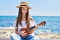 Adorable girl tourist smiling confident playing ukulele at seaside Royalty Free Stock Photo