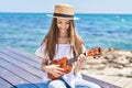 Adorable girl tourist smiling confident playing ukulele at seaside Royalty Free Stock Photo