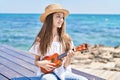 Adorable girl tourist smiling confident playing ukulele at seaside Royalty Free Stock Photo