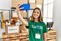 Adorable girl wearing volunteer uniform make selfie by the smartphone at charity center Royalty Free Stock Photo