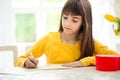 Adorable girl writing greeting card