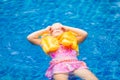 Adorable girl with yellow life vest in pool in tropical beach re