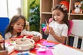 Adorable girls student cutting paper drawing on paper at kindergarten Royalty Free Stock Photo