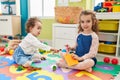 Adorable girls student cutting paper playing with dinosaur toy at kindergarten Royalty Free Stock Photo