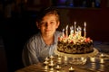 Adorable happy blond little kid boy celebrating his birthday. Preteen child blowing candles on homemade baked cake Royalty Free Stock Photo