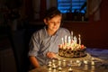 Adorable happy blond little kid boy celebrating his birthday. Preteen child blowing candles on homemade baked cake Royalty Free Stock Photo