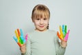 Adorable happy child girl art school student showing her colorful painted hands on white. Girl drawing Royalty Free Stock Photo