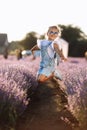 Adorable happy child girl is having fun and jumping in lavender field on summer warm day. Hyperactive smiling little kid Royalty Free Stock Photo