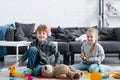 adorable happy children sitting on floor and playing with toys Royalty Free Stock Photo